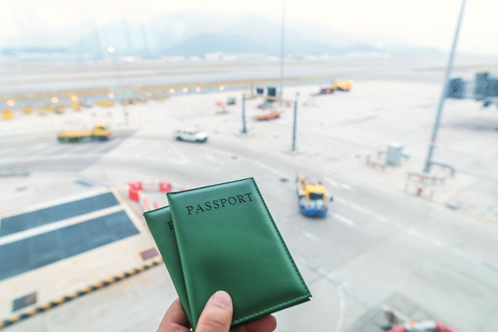 Hand holding passports on the background of airport
