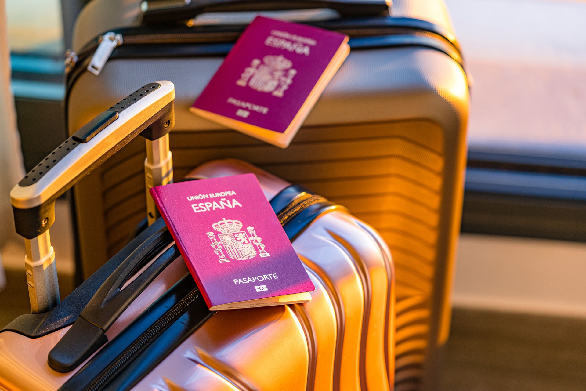Two Spanish passports on suitcases in hotel room